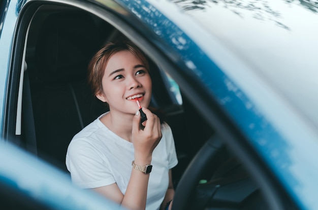 Mujer aplicando lápiz labial en el coche