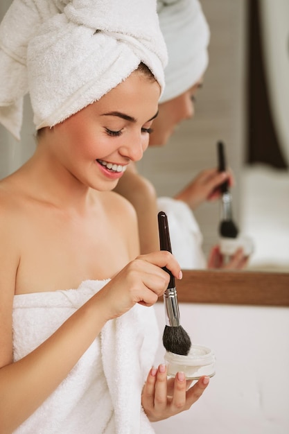 Mujer aplicando maquillaje en la cara en casa