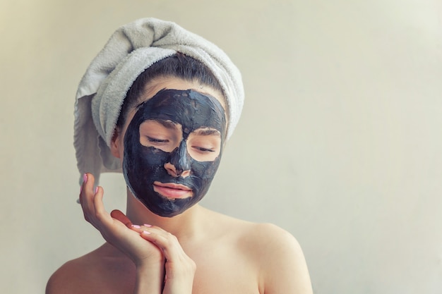 Mujer aplicando máscara nutritiva negra en la cara