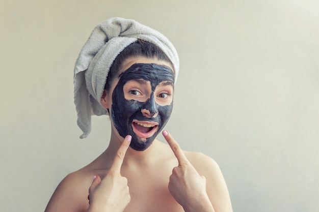 Mujer aplicando máscara nutritiva negra en la cara