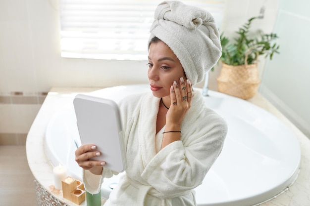 Foto mujer aplicando suero facial