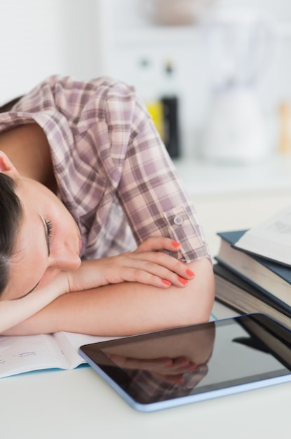 Foto mujer apoyada en la mesa y descansando