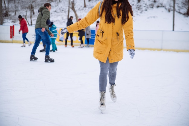 La mujer aprende a esquiar en la pista de hielo de la ciudad