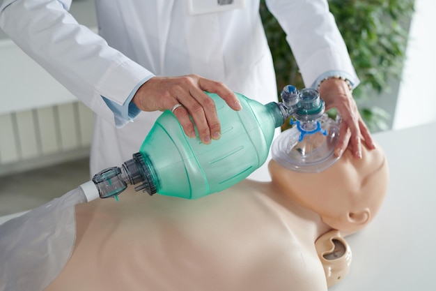 Mujer aprendiendo a hacer respiración artificial en maniquí