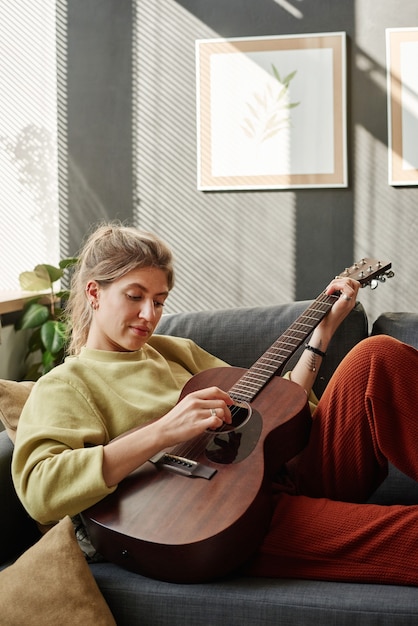 Mujer aprendiendo a tocar la guitarra