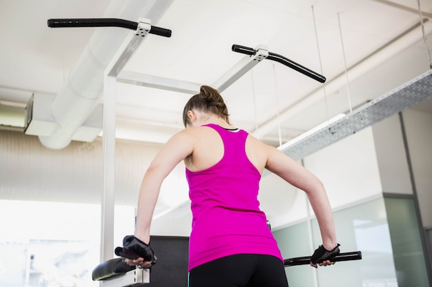 Mujer apta haciendo levantarse en el gimnasio