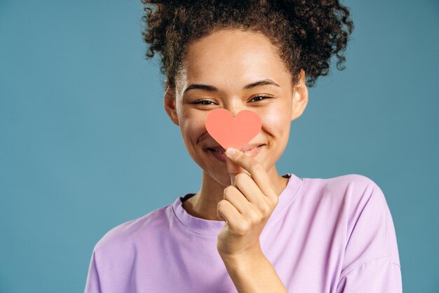 Mujer apunta a la cámara símbolo de corazón rosa de concienciación sobre el cáncer de mama