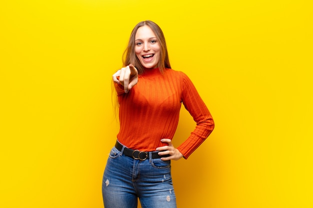 mujer apuntando a la cámara con una sonrisa satisfecha, segura y amigable, eligiéndote