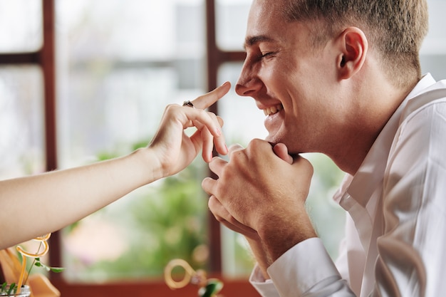 Mujer apuntando a la nariz de novios