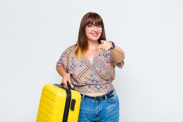 Mujer apuntando con una sonrisa satisfecha, segura y amistosa