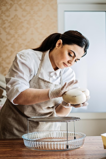 Mujer árabe de asia central chef de repostería haciendo pastel de mousse de glaseado de espejo femenino de oriente medio