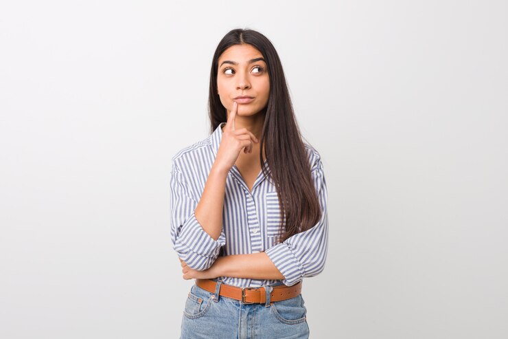 Foto mujer árabe bonita joven que mira de lado con la expresión dudosa y escéptica.