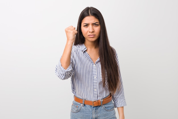 Foto mujer árabe bonita joven que muestra el puño a la cámara, expresión facial agresiva.