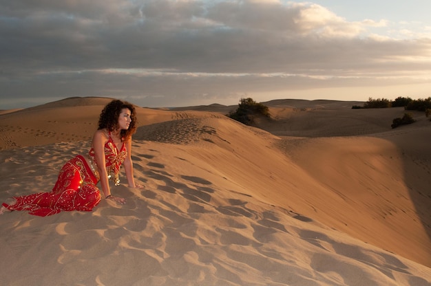 Mujer árabe en las dunas del desierto al atardecer