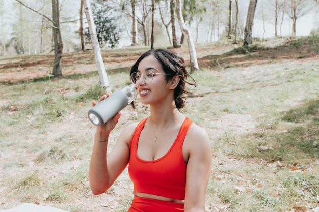 Mujer árabe haciendo posiciones de yoga durante un tren al aire libre por la mañana, aprendiendo un nuevo concepto deportivo. Copie las imágenes del espacio, estirando y haciendo posiciones de yoga. Paños deportivos durante un día soleado. Cuidados personales