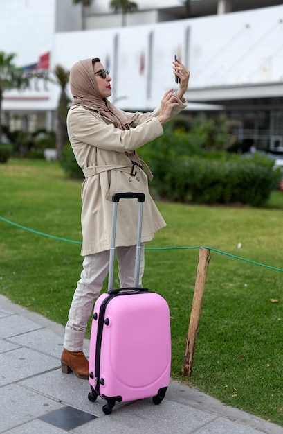 Mujer árabe con hijab tomando una selfie