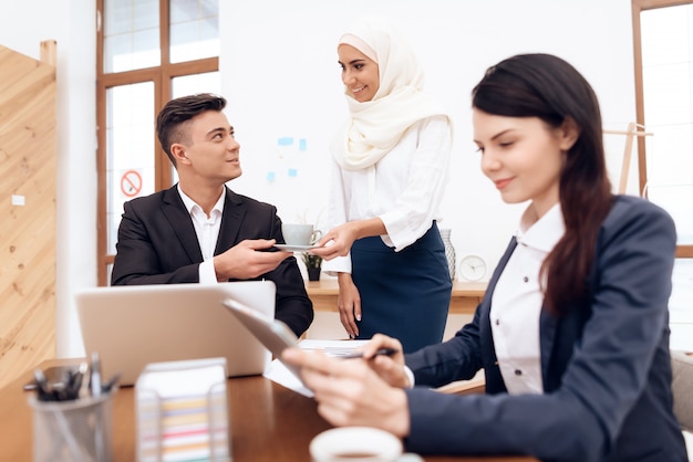 Mujer árabe en hijab trabaja en la oficina juntos.