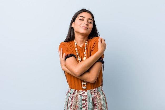 La mujer árabe joven abraza, sonriendo despreocupado y feliz.