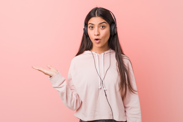 La mujer árabe joven que escuchaba la música impresionó llevar a cabo el espacio de la copia en la palma.