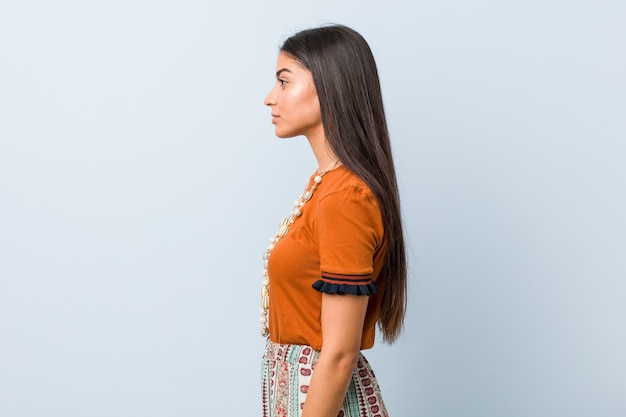 Foto la mujer árabe joven que mira a la izquierda, de lado plantea.