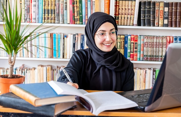 Mujer árabe musulmana estudiando en línea