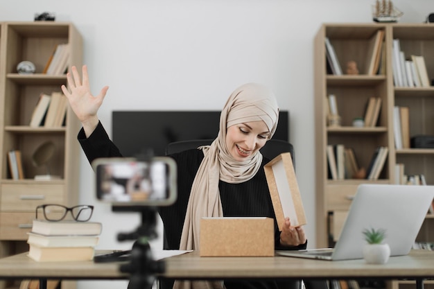 Mujer árabe que usa la cámara de un teléfono inteligente para crear contenido