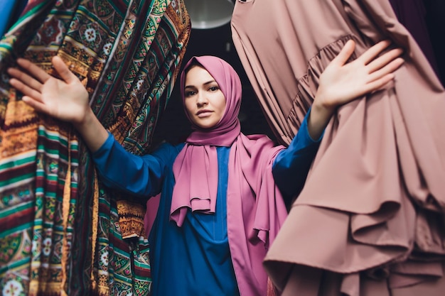 Foto mujer árabe vestida tradicional musulmana compra un vestido nuevo en una tienda oriental