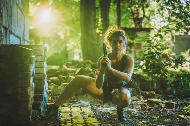 Mujer con un arma en un bosque