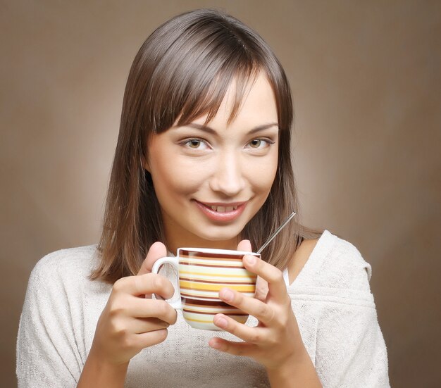 Mujer con un aromático café en manos