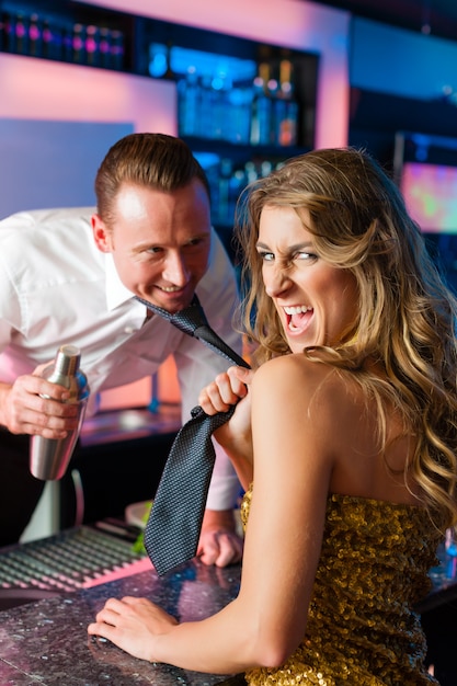 Mujer arrastrando barman en club o bar