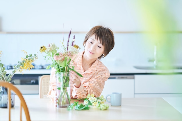 Mujer arreglando flores con florero