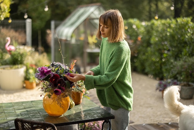 Mujer arreglando hermosas flores en ramo al aire libre