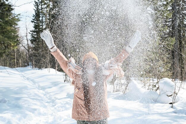 Mujer arrojando nieve al aire