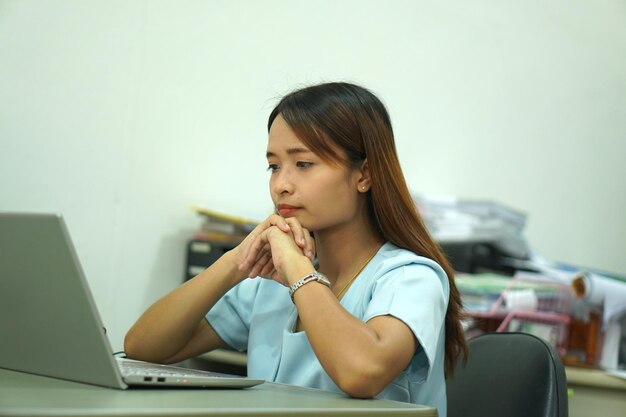 Mujer asiática analizando el plan de trabajo de la computadora