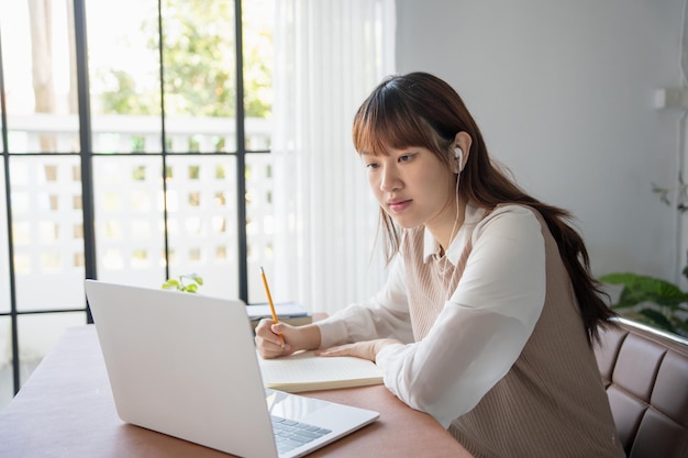 Mujer asiática aprendiendo en línea por computadora portátil