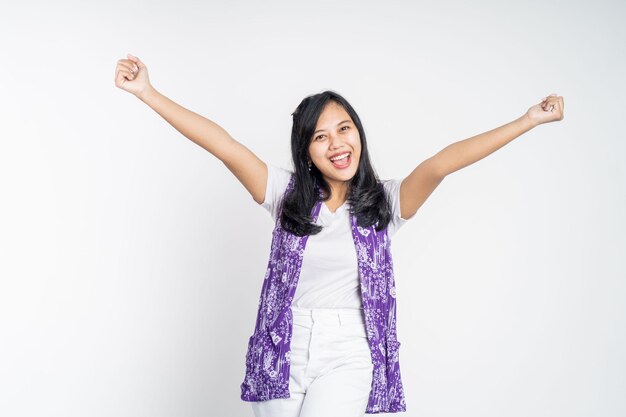 Mujer asiática apretando las manos mientras celebra el éxito