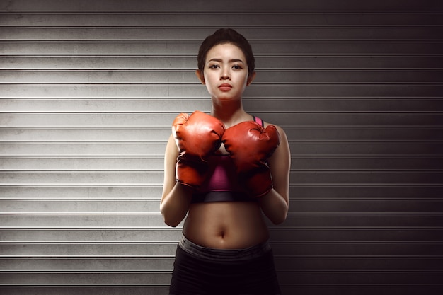 Mujer asiática de la aptitud con los guantes de boxeo rojos