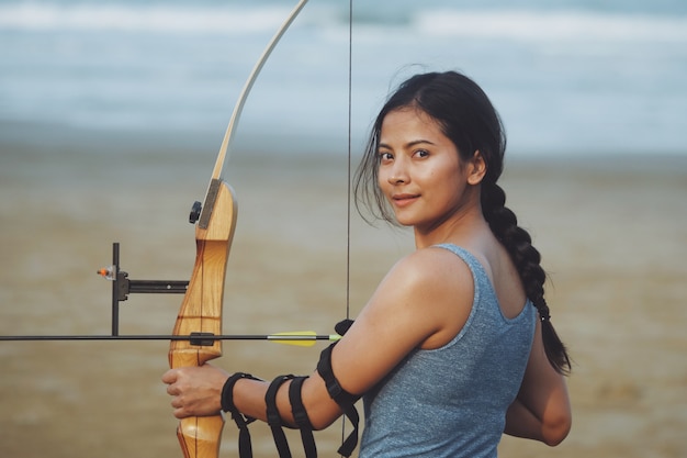 Mujer asiática con arco arachery