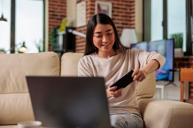 Mujer asiática de aspecto auténtico jugando videojuegos móviles en línea en el teléfono ganando y emociones felices. Aplicación de videojuegos en Internet Juegos para ver películas Comunicación social en Internet