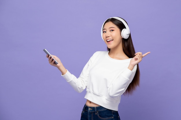 Mujer asiática con auriculares escuchando música desde el teléfono inteligente