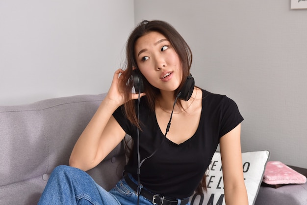Mujer asiática en auriculares con smartphone