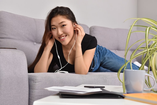 Mujer asiática en auriculares con smartphone