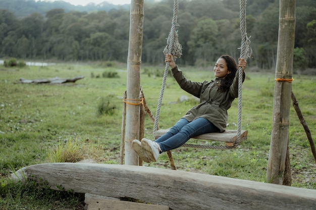 Mujer asiática se balancea en un campo