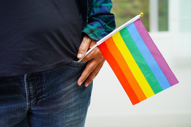 Mujer asiática con la bandera del arco iris Símbolo de los derechos LGBT e igualdad de género Mes del Orgullo LGBT en junio