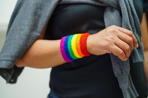 Mujer asiática con la bandera del arco iris Símbolo de los derechos LGBT e igualdad de género Mes del Orgullo LGBT en junio