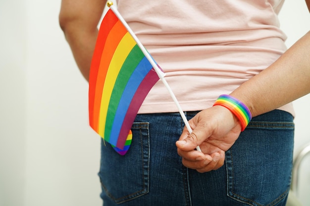 Foto mujer asiática con la bandera del arco iris símbolo de los derechos lgbt e igualdad de género mes del orgullo lgbt en junio