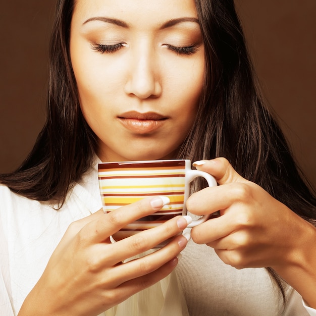 Mujer asiática bebiendo café o té