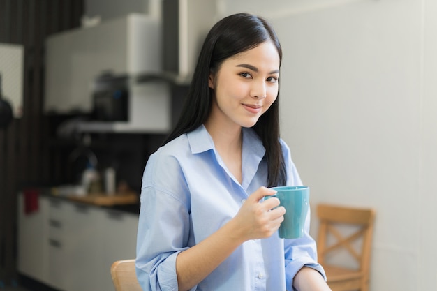 Mujer asiática bebiendo café quedarse en casa por la mañana.