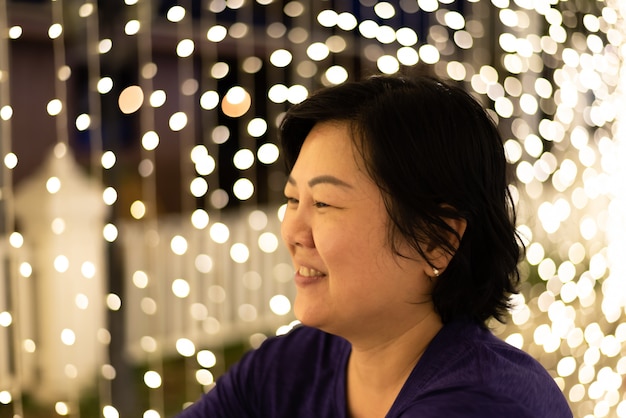 Mujer asiática con bokeh de luz para feliz año nuevo