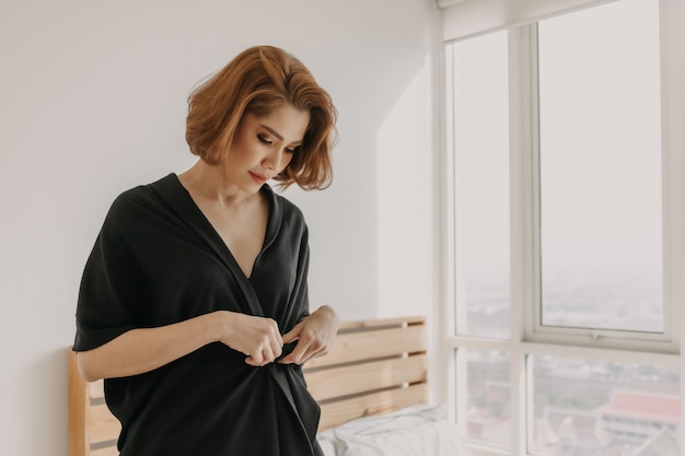 Mujer asiática bonita de aspecto fresco en vestido negro